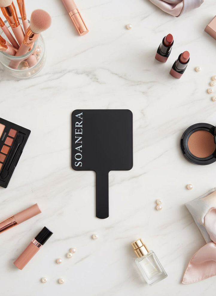Black Mirror with white brand logo placed on table surrounded by cosmetic products 