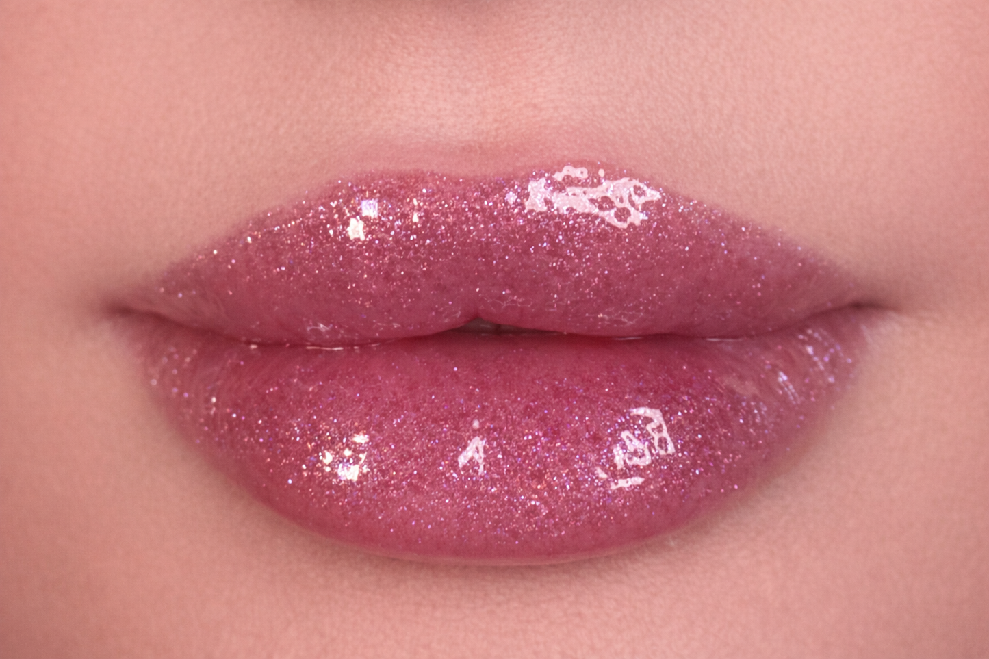 Close-up of lips wearing SOANERA pink shimmer lip gloss-oil with sparkles