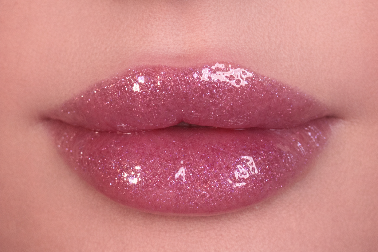 Close-up of lips wearing SOANERA pink shimmer lip gloss-oil with sparkles